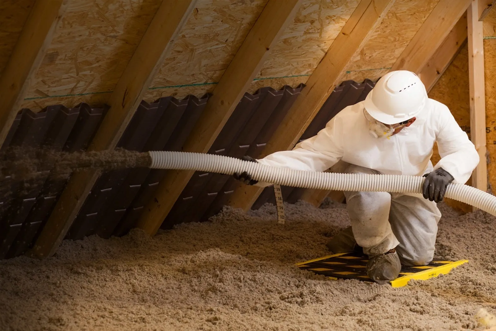 A man in white shirt and hat working on the floor.