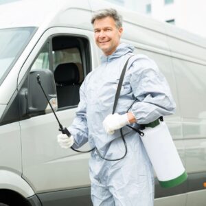 A man in a hazmat suit holding a spray bottle.
