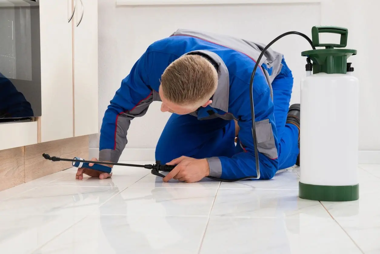 A man in blue work suit working on the floor.